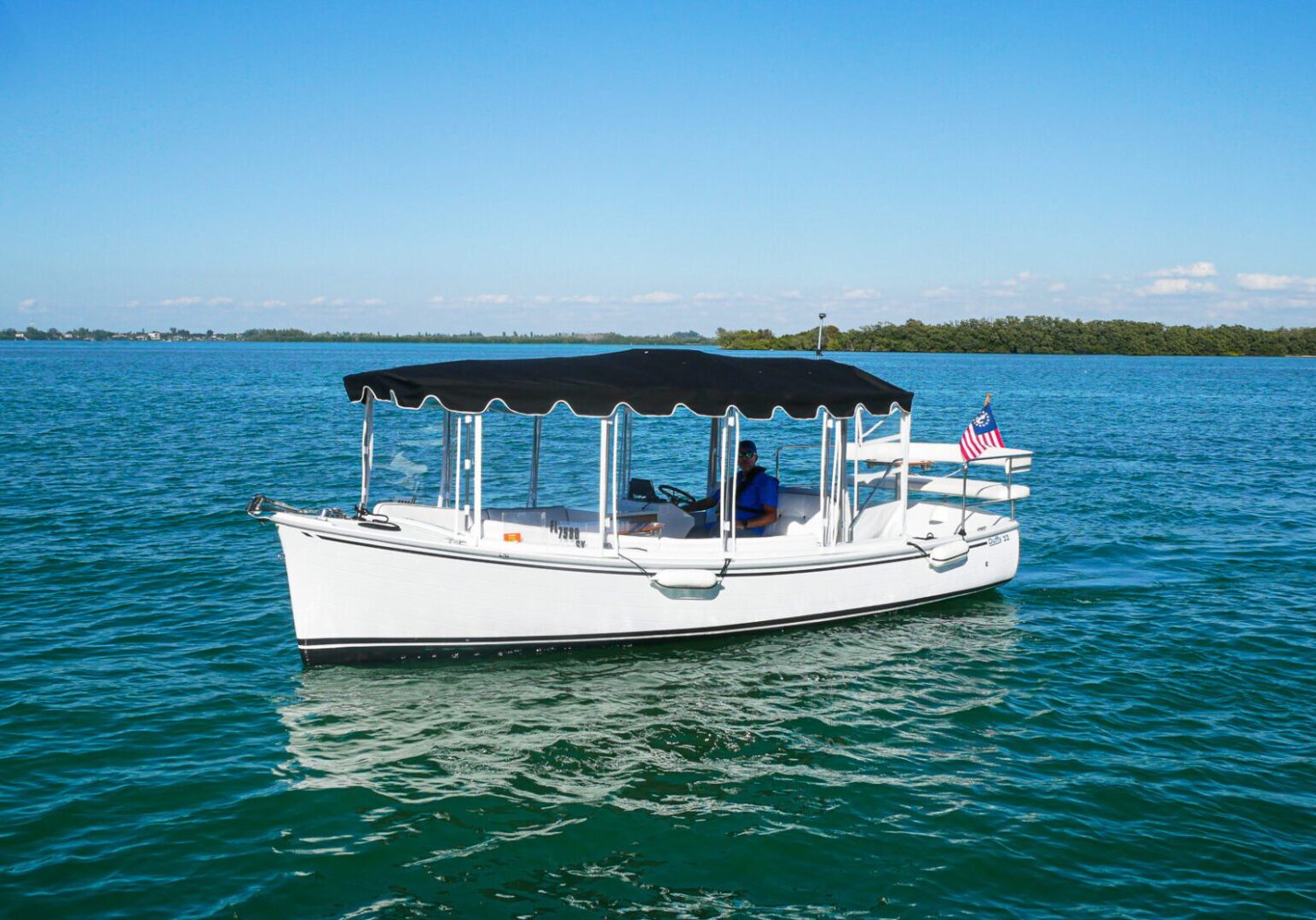 a man seating in the boat with a flag on it